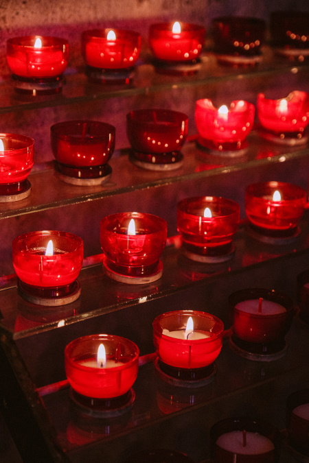 Rows of small candles in red glass holders